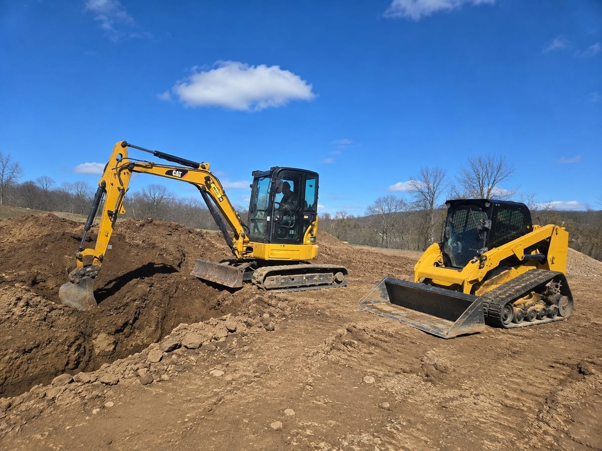 Excavation crew cutting and grading a Pittsburgh site with CAT machinery