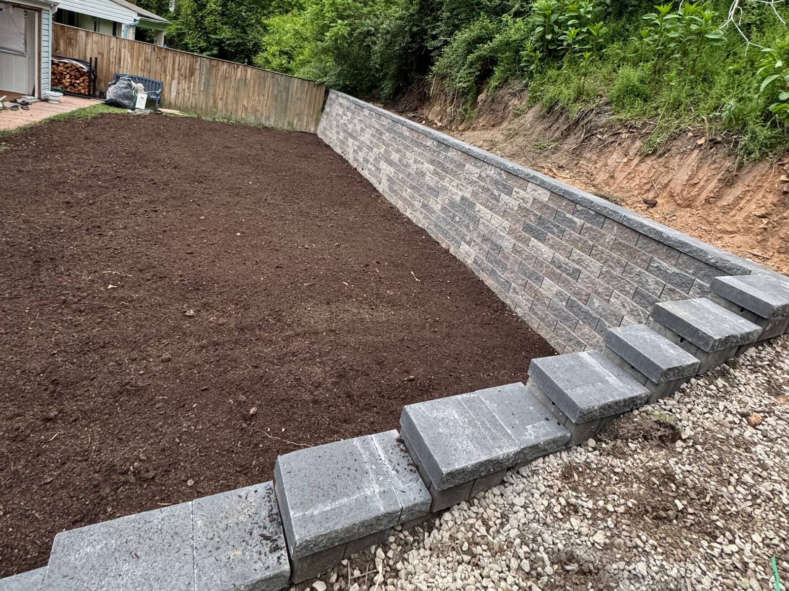 Segmental block retaining wall with stepped caps holding a regraded Pittsburgh hillside